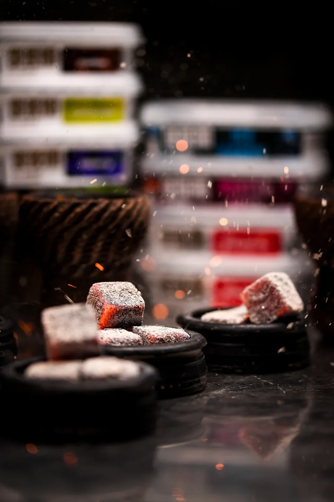 Hookah bowls with glowing coals and flying sparks during preparation